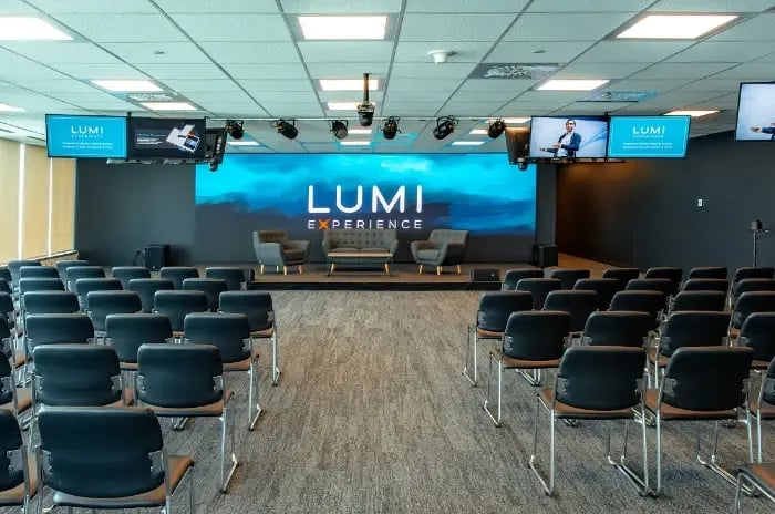 Montreal meeting room from middle aisle of audience chairs with interview set up on stage