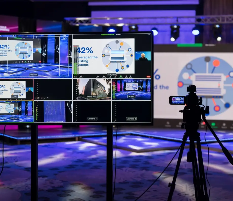 screen in studio showing broadcast with camera next to it