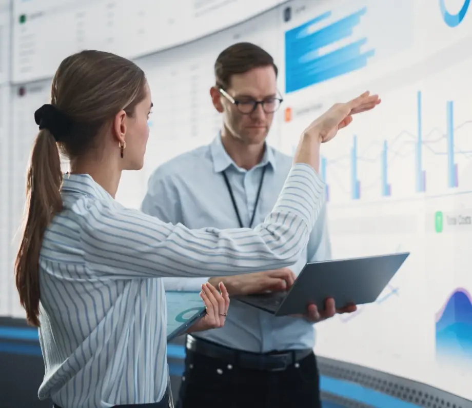 Woman and man in front of large screen