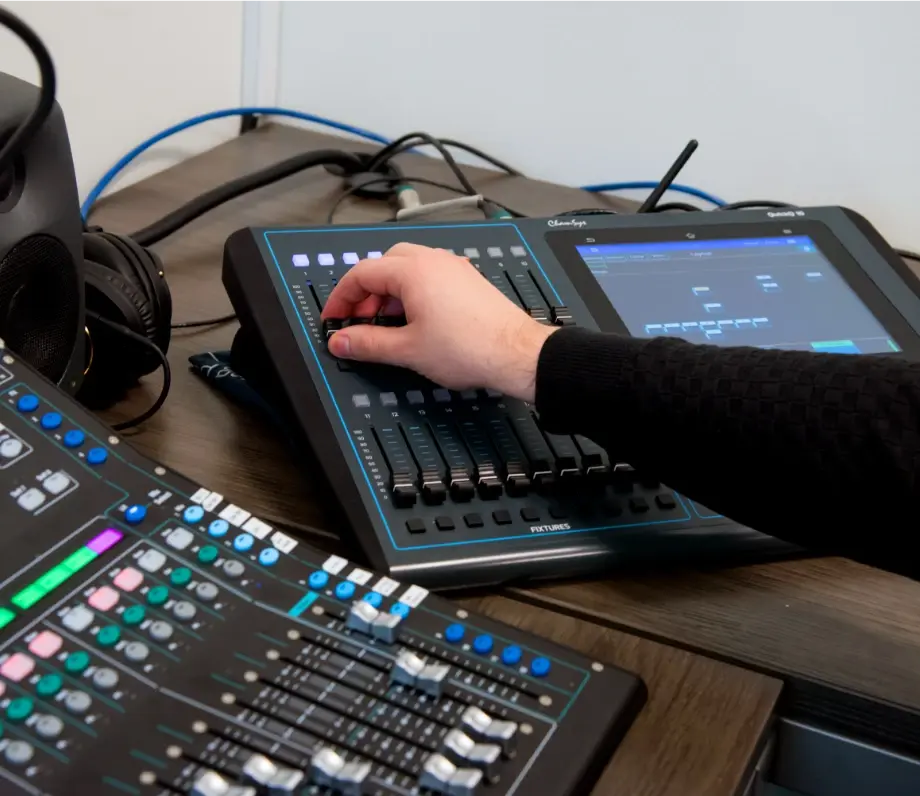 hand adjusting levels on a soundboard