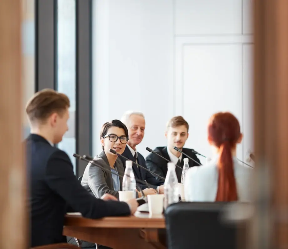 Group of people at meeting table with microphones